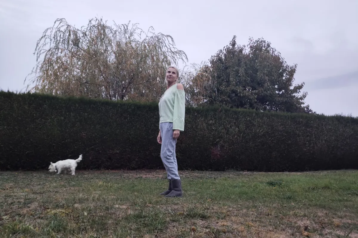 Rosalba Meslier dans son jardin à Mareil-sur-Mauldre, devant la haie, avec son chien
